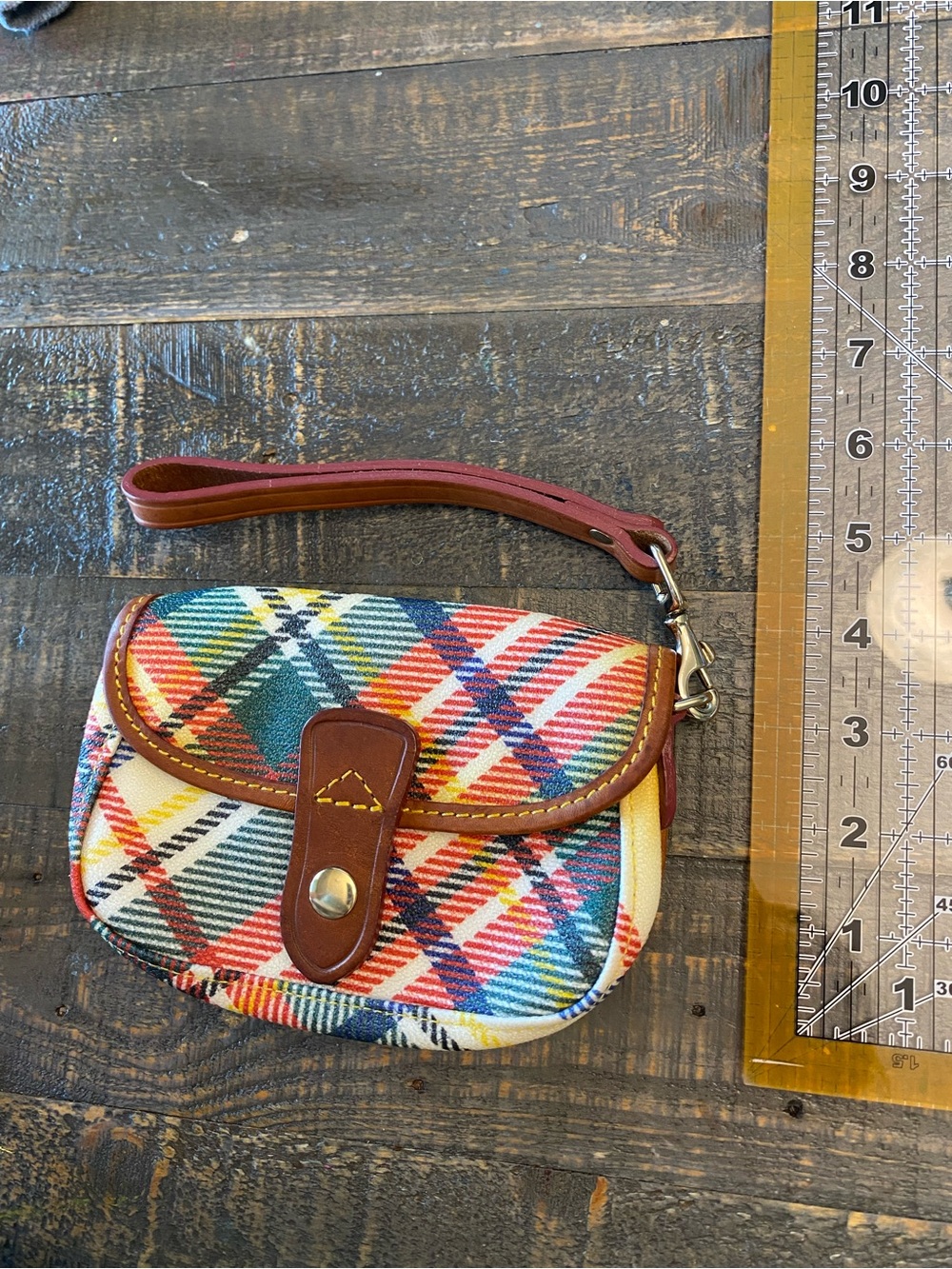 Dooney & Bourke tartan plaid coated cotton flap wristlet with leather trim.